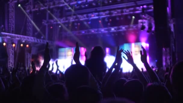 Mensen applaudisseren naar muziekband, geweldige sfeer in de muziek en lichtshow - Video