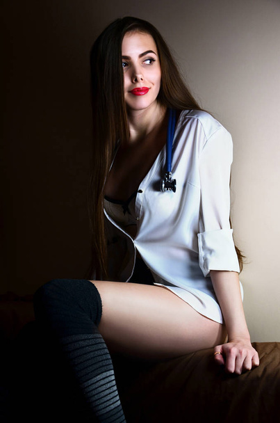 Young nurse girl sitting with stethoscope - Foto, Imagen