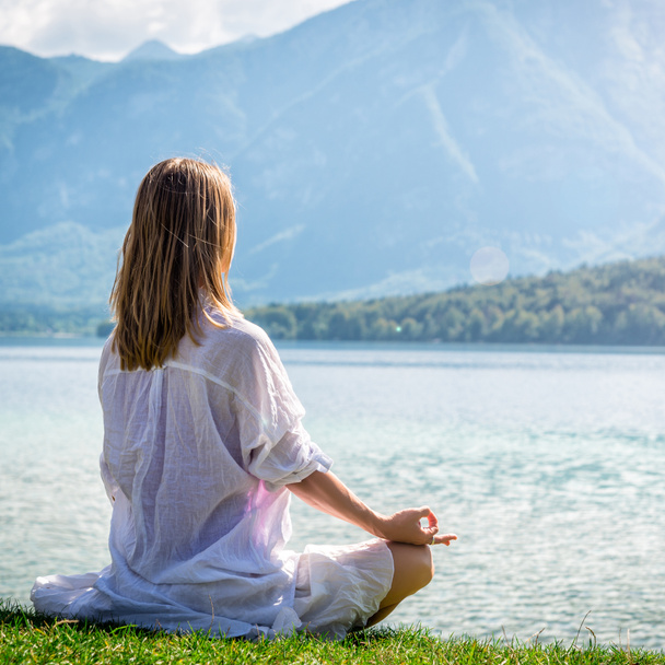 Mulher meditando no lago
 - Foto, Imagem