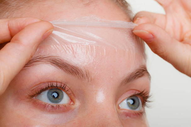Woman removing facial peel off mask closeup - Foto, imagen