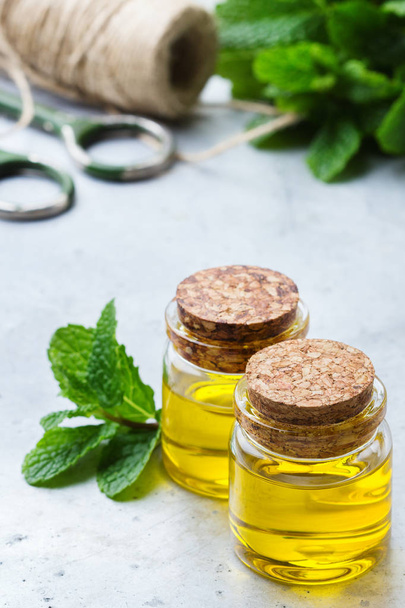 Organic essential mint oil with green leaves - Photo, Image