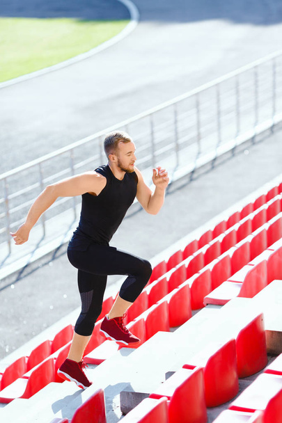 Esportista correndo em tribuno
 - Foto, Imagem