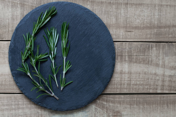 Bacground with fresh rosemary on a slate plate  - Foto, imagen