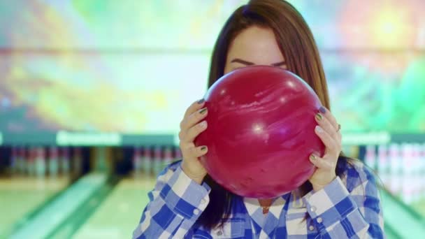 Dziewczyna wychodzi zza bowling ball - Materiał filmowy, wideo