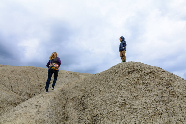 Moeder en zoon modderige vulkaan te bezoeken. Familie klimmen droge dorre  - Foto, afbeelding