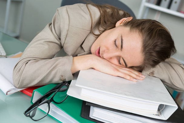 young woman sleeping at workplace - Fotó, kép