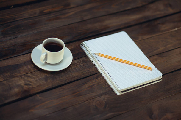 Ноутбук в карандаше и чашку кофе на деревянном фоне
 - Фото, изображение
