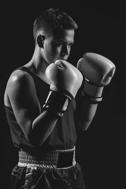 Young boxer sportsman on black background - Valokuva, kuva