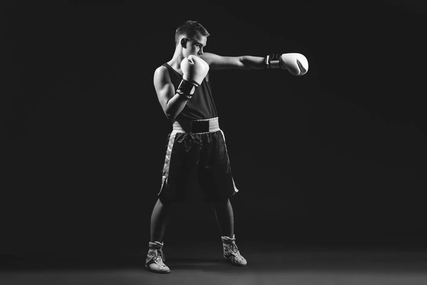Fiatal bokszoló sportoló fekete háttér - Fotó, kép