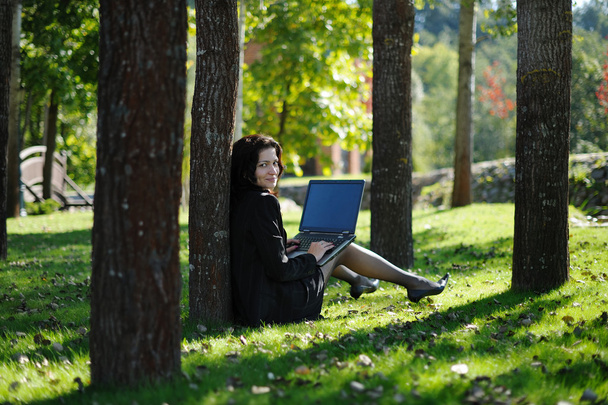 Young lady with a notebook in a park - Photo, Image
