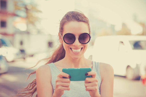 happy girl looking at phone seeing news or photos - Foto, Imagen