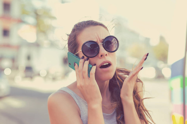 Frustrated woman talking on phone - 写真・画像