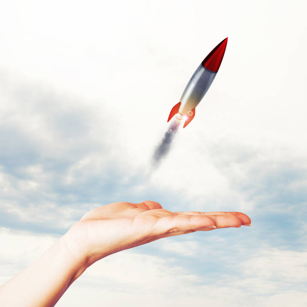 Businesswoman holding a small rocket - Photo, Image