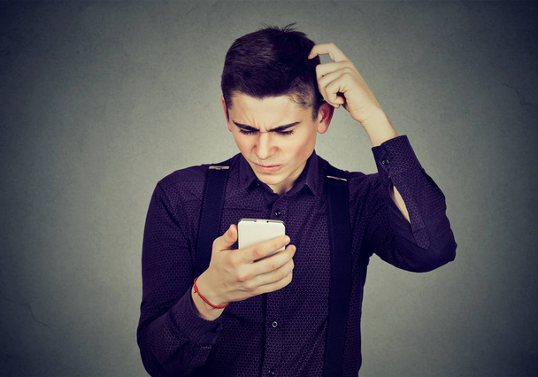 Funny clueless dumb guy having troubles with his smartphone - Foto, imagen