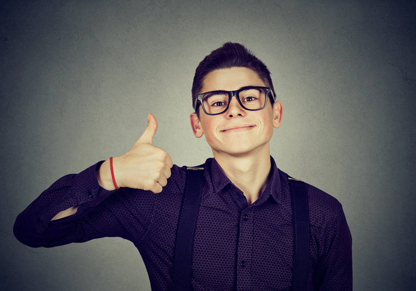 Successful teenager. Nerdy man giving thumbs up hand gesture sign  - 写真・画像