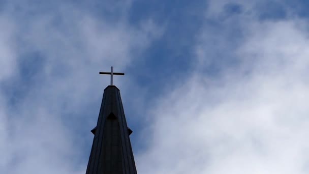 um campanário gótico da torre com uma cruz nela e nuvens bonitas que flutuam no movimento lento
 - Filmagem, Vídeo