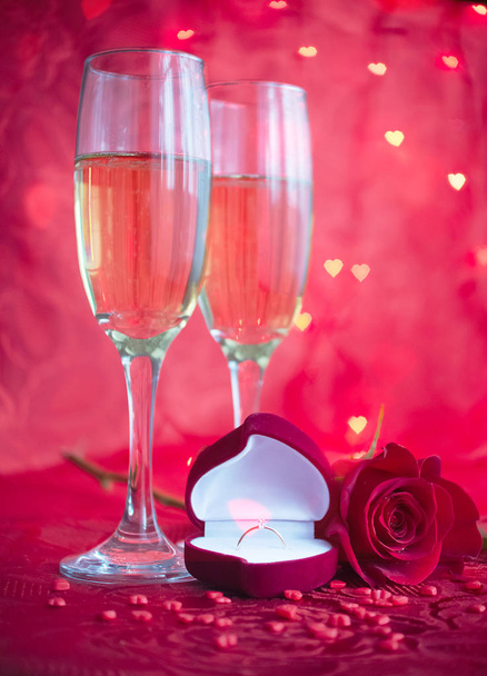 Ρομαντικό setup με σαμπάνια, τριαντάφυλλο και δαχτυλίδι αρραβώνων - Φωτογραφία, εικόνα