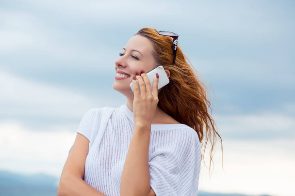 young happy woman talking on mobile phone on a beach with ocean sea background, Sardinia Italy  - Zdjęcie, obraz