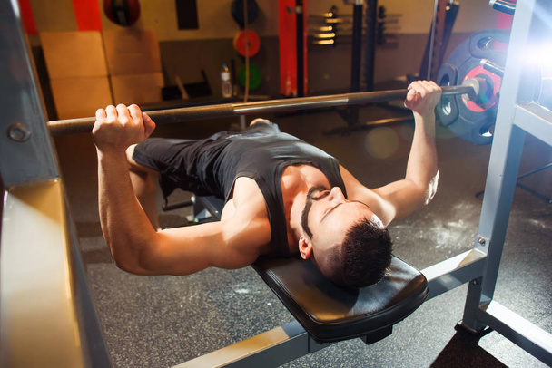 Young Man In Gym Exercising Chest On The Bench Press - Foto, Bild