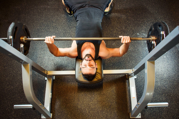 Young Man In Gym Exercising Chest On The Bench Press - Foto, imagen