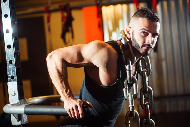 Muscular man working out in gym doing exercises on parallel bars - Fotoğraf, Görsel