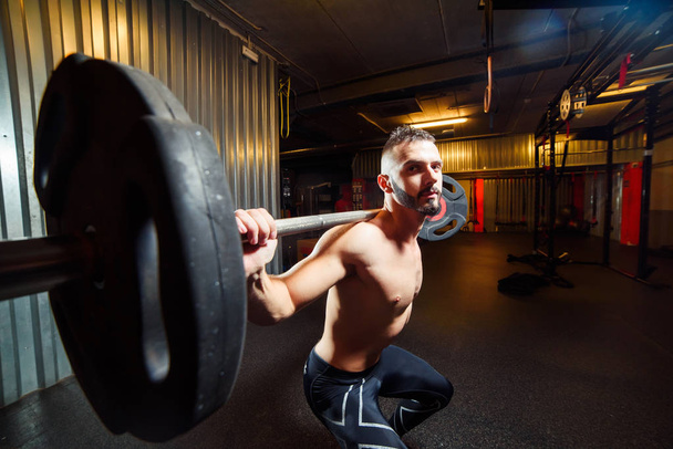 Muscular man training squats with barbells at gym - Foto, Imagem