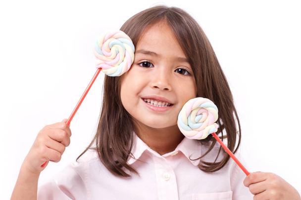 playful cute little girl posing with sweet pastel color marshmallow - Photo, Image