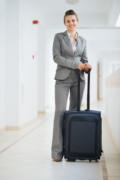 Portrait of business woman in business trip with wheel bag - Zdjęcie, obraz