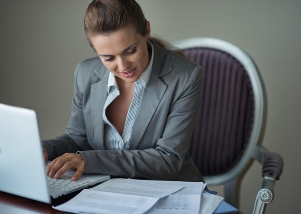 деловая женщина, работающая с документами и ноутбуком - Фото, изображение