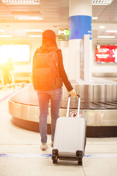Matkailija naiset odottavat laukku mpty matkatavaroiden korvausalueella lentokentällä
 - Valokuva, kuva