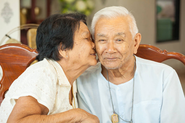 Asiatico anziano womman baci anziano uomo a casa
 - Foto, immagini