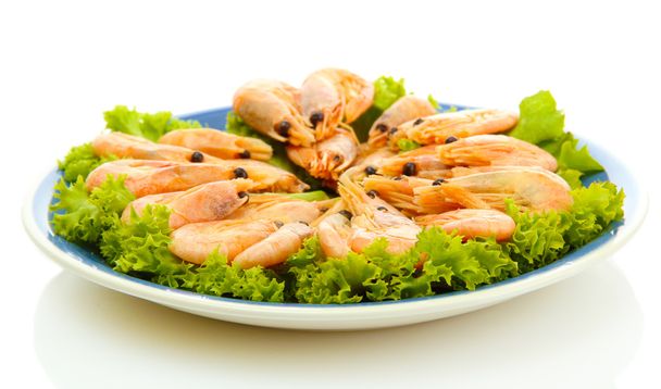 Boiled shrimps with lettuce leaves on plate, isolated on white - Фото, изображение