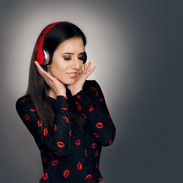 Το κορίτσι με τα κόκκινα ακουστικά να ακούτε ένα τραγούδι αγάπης - Φωτογραφία, εικόνα