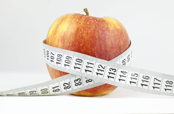 Apple surrounded by a measuring tape Health and fitness concept - Foto, Bild