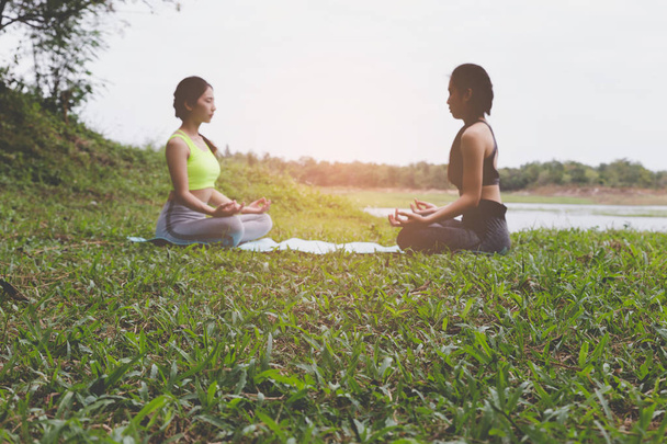 jovem mulher medita enquanto pratica ioga ao ar livre no parque, re
 - Foto, Imagem