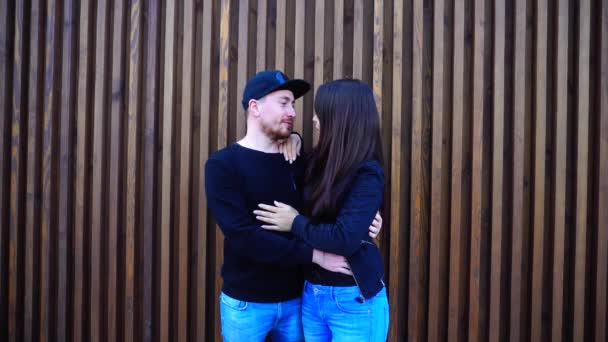 若い恋人たちは昼間会ったレストラン屋外の木製の壁の近くに強い抱擁とキス、お互いを保持します。. - 映像、動画