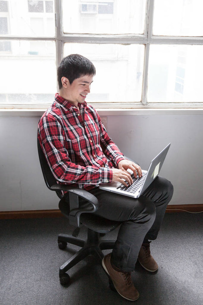 Genç adam dizüstü bilgisayar kullanıyor  - Fotoğraf, Görsel