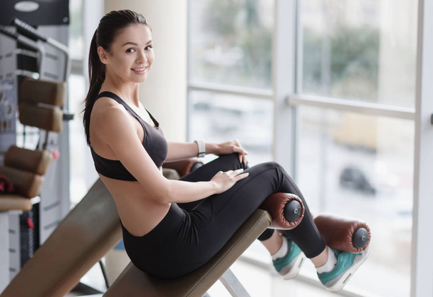 Активна дівчина сидить у спортзалі після тренування
 - Фото, зображення