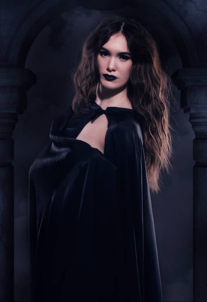 Gyönyörű gótikus lány egy fekete köpenyt, szemben a nightscape-t - Fotó, kép