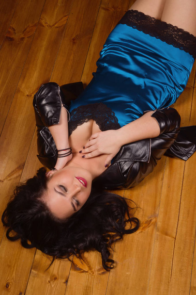 junge Frau in kurzem Spitzenkleid liegt auf dem Fußboden - Foto, Bild