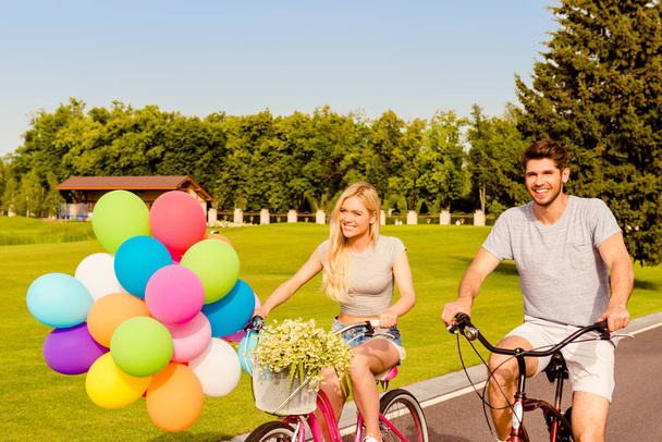 Portrait of cheerful man and woman with balloons spending summer - Foto, Imagen