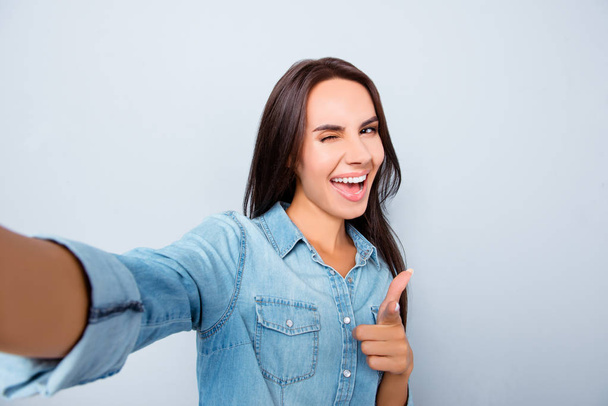 Selfie of happy woman showing thumb up and winking - Foto, Bild