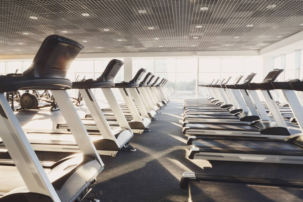 Interior moderno ginásio com equipamentos, esteiras para treinamento de cardio fitness
 - Foto, Imagem