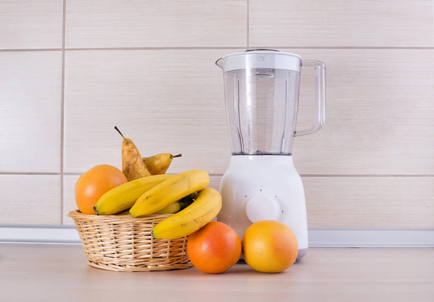 Blender with fruits on kitchen countertop - 写真・画像