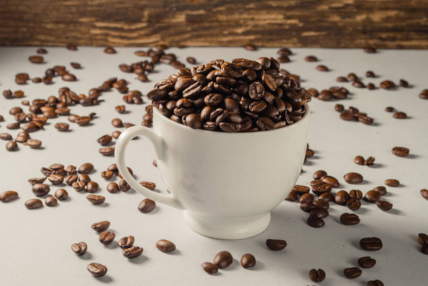 中立的な灰色の背景にコーヒー豆。ダーク ロースト コーヒー.  - 写真・画像