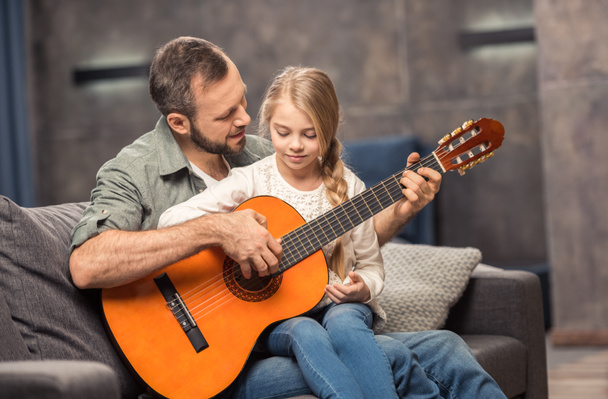 отец и дочь играют на гитаре
 - Фото, изображение