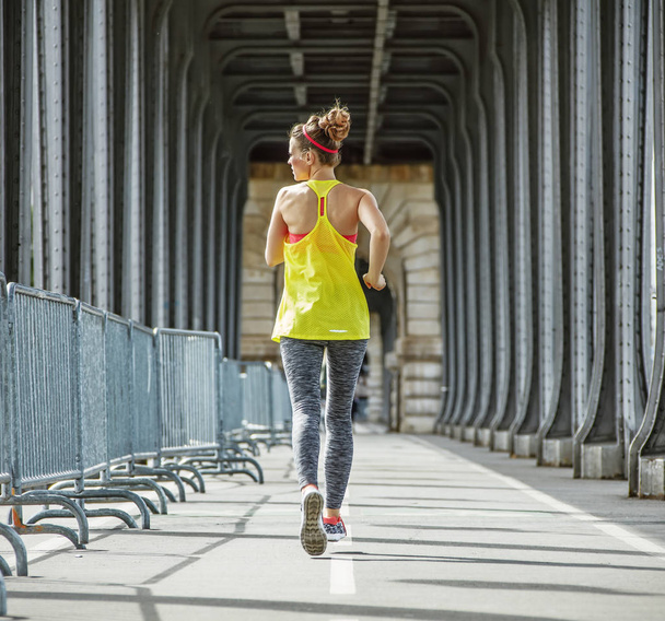 sportswoman jogging on Pont de Bir-Hakeim bridge in Paris - Fotó, kép