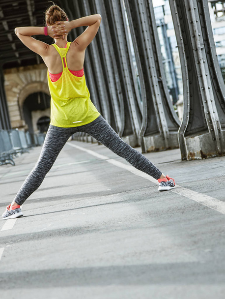 woman jogger stretching on Pont de Bir-Hakeim bridge in Paris - Φωτογραφία, εικόνα