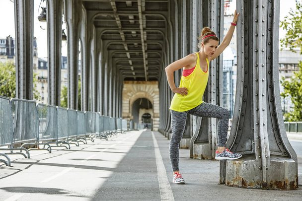 woman jogger relaxing after workout on Pont de Bir-Hakeim bridge - Foto, Imagem