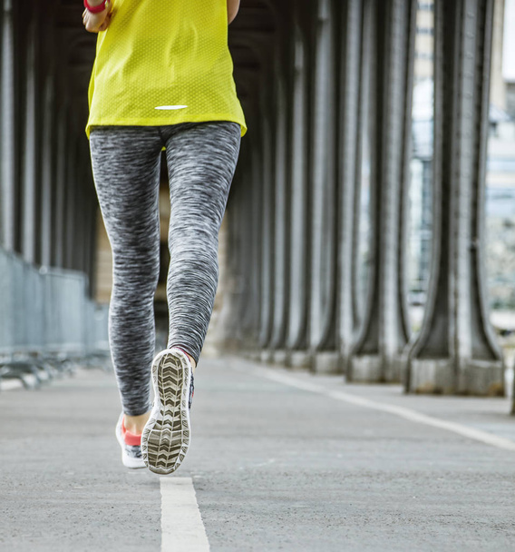 Closeup on woman jogger running on Pont de Bir-Hakeim bridge - 写真・画像